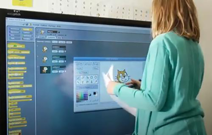 Manipulation de l’application Scratch par une élève sur un écran interactif